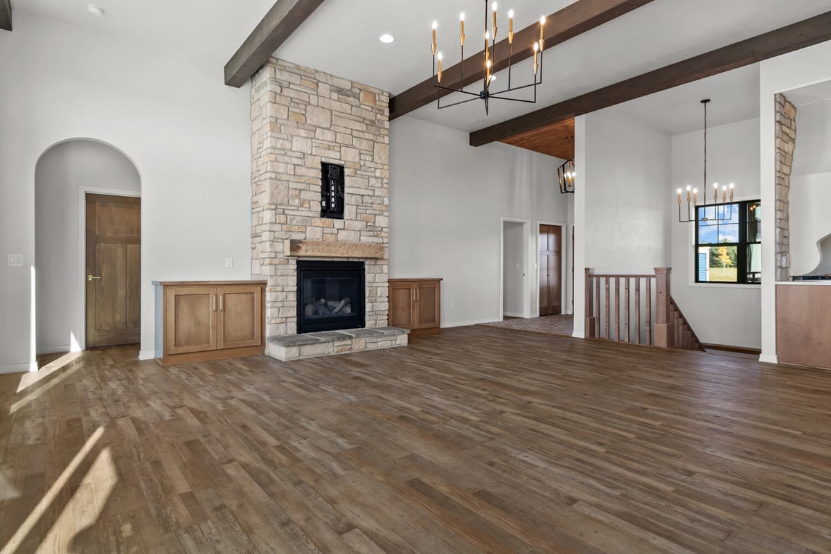 Stone fireplace in open living room by Midwest Design Homes in Lawrence, Wisconsin