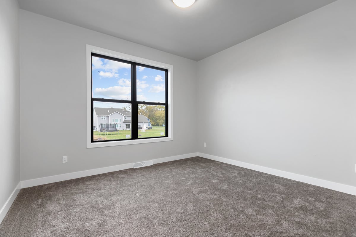 Carpeted bedroom with natural light in a custom-built home by Midwest Design Homes, Kaukauna
