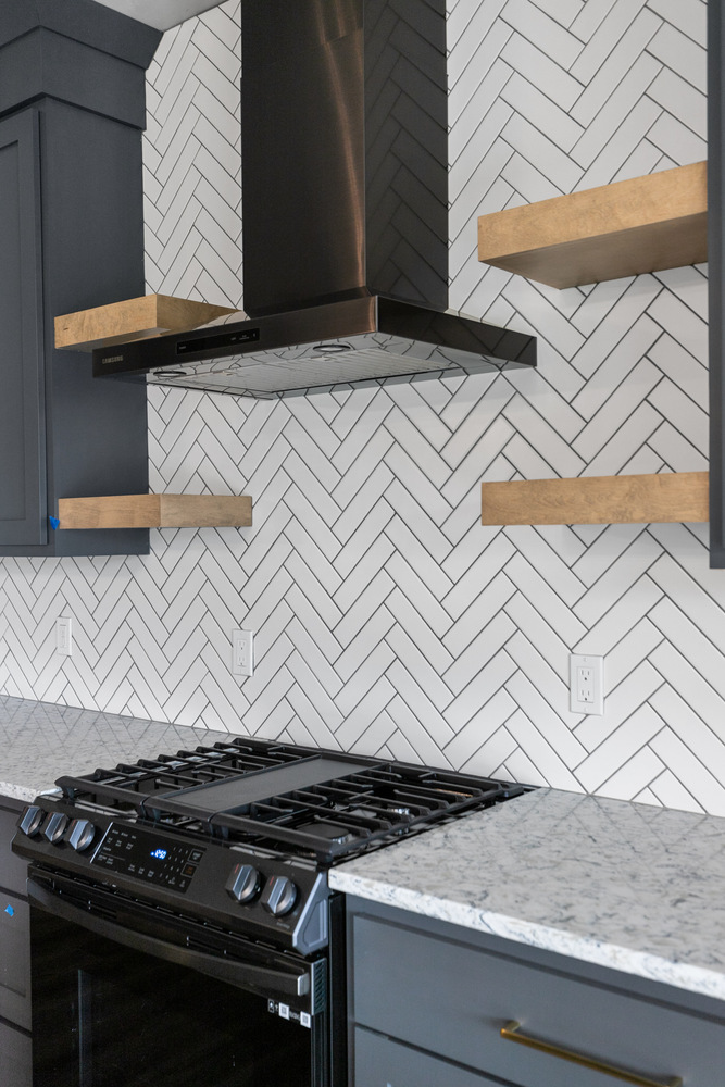Close-up of gas range and tile backsplash by Midwest Design Homes in Bellevue Wisconsin