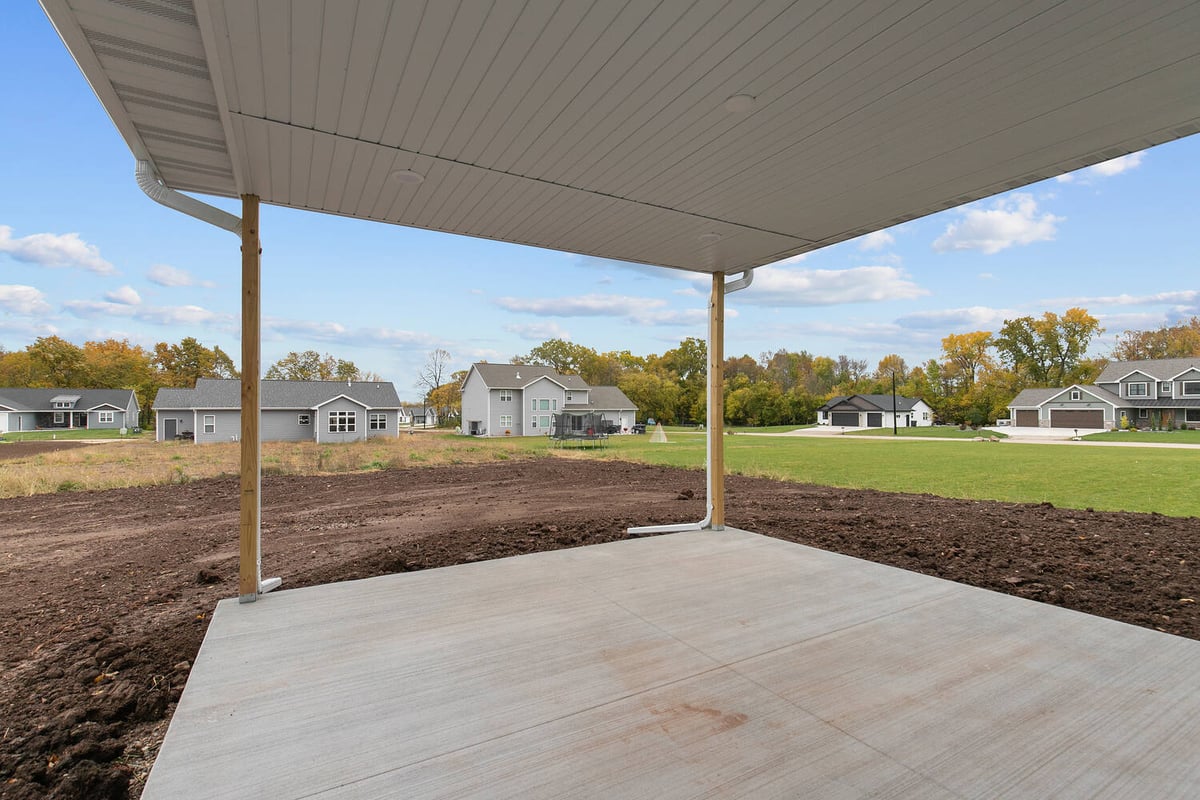 Covered concrete patio and backyard view in Kaukauna custom build by Midwest Design Homes