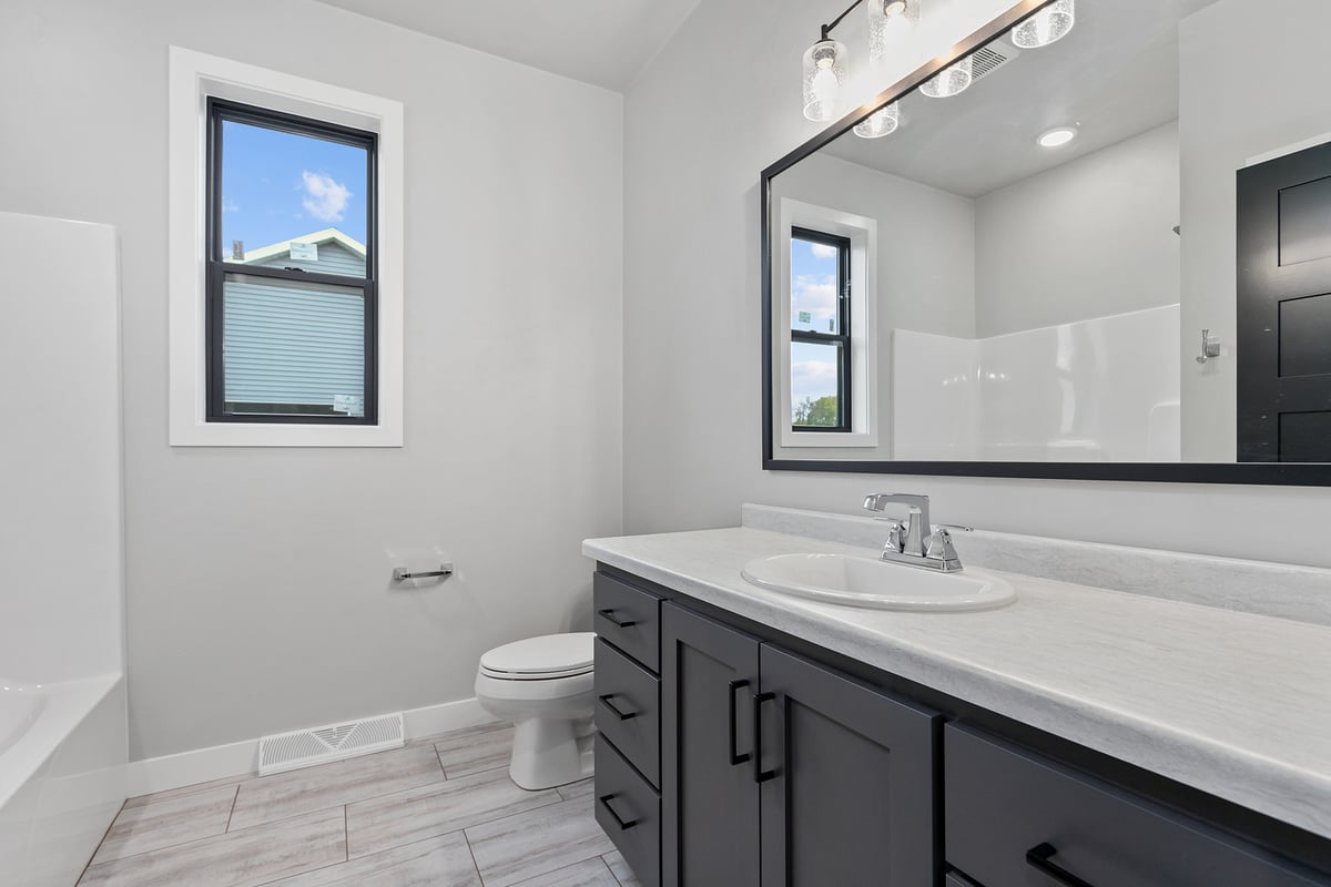 Custom bathroom with white vanity and black cabinets by Midwest Design Homes in Kaukauna, WI