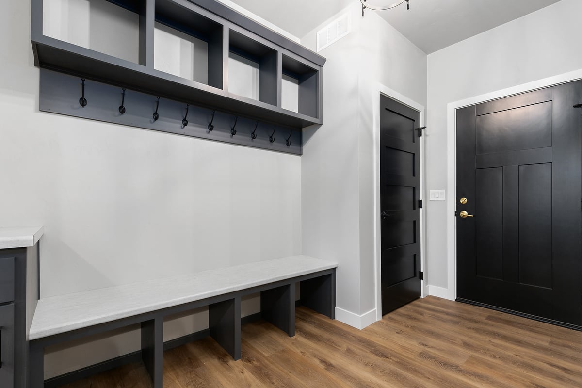 Custom mudroom with hooks, bench, and storage by Midwest Design Homes in Kaukauna