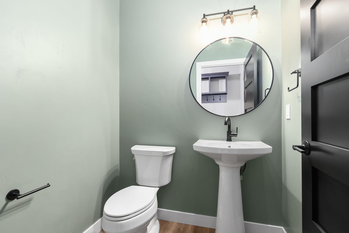 Custom powder room with soft green walls in Kaukauna by Midwest Design Homes