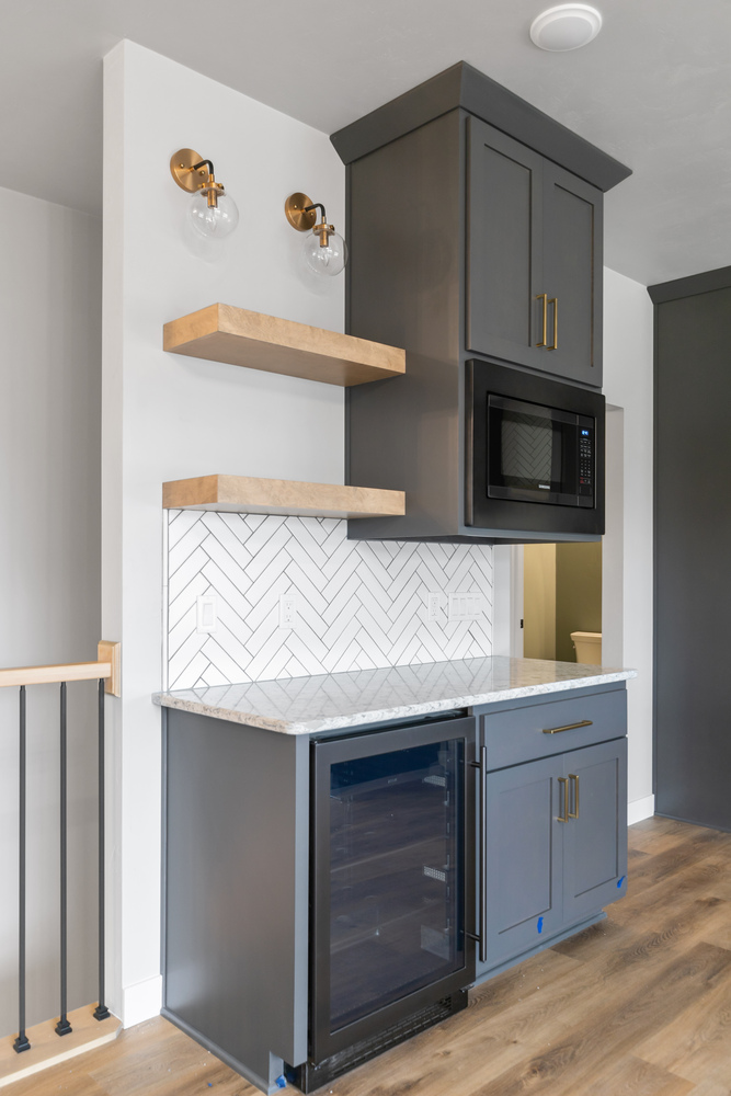 Dark cabinetry and floating shelves in custom kitchen by Midwest Design Homes in WI