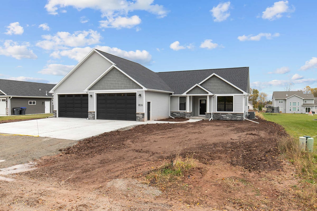 Front view of new custom home by Midwest Design Homes in De Pere WI with black garage doors