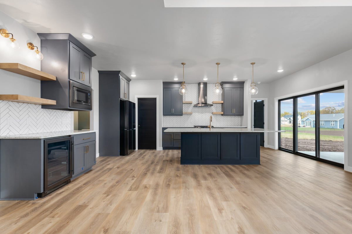 Full kitchen layout with island and sliding doors in Kaukauna home by Midwest Design Homes