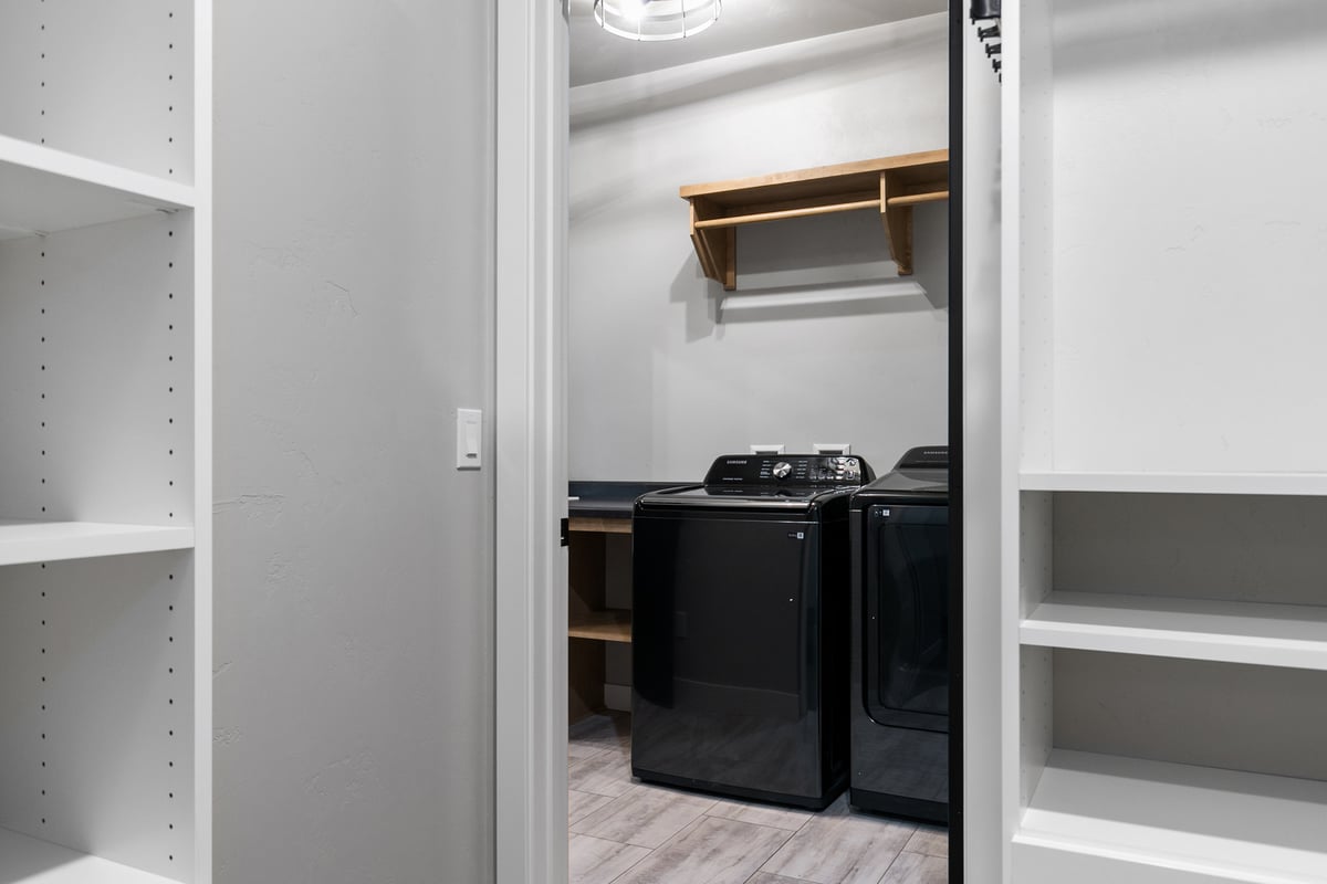 Laundry room with washer and dryer seen from closet in Kaukauna home by Midwest Design
