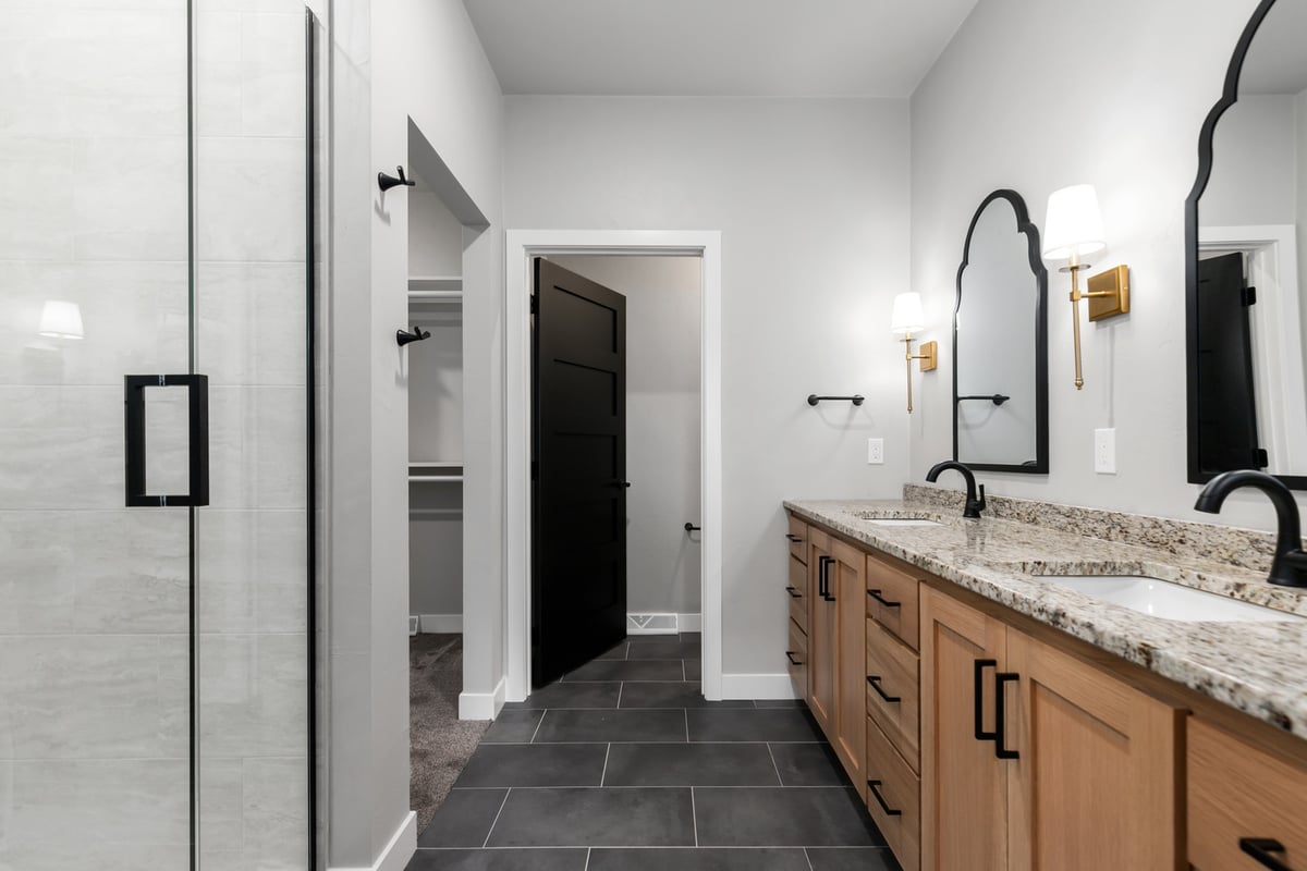 Master bathroom entry view with vanity and closet by Midwest Design Homes in Ellington WI