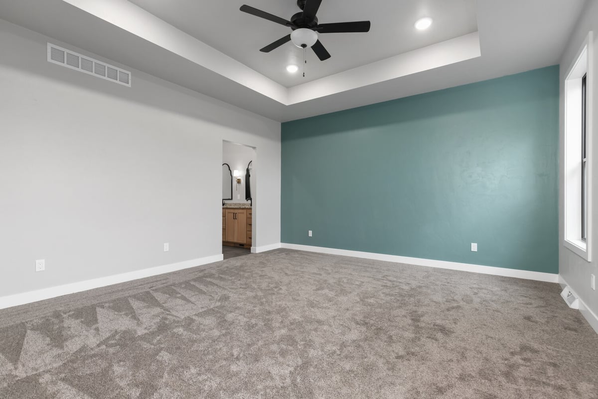 Master bedroom with teal accent wall and bath entry by Midwest Design Homes in Green Bay WI