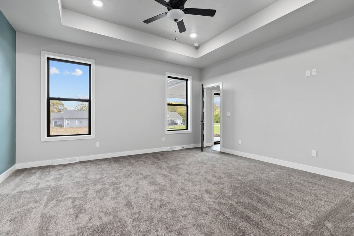 Master bedroom with tray ceiling and fan by Midwest Design Homes in Ledgeview Wisconsin