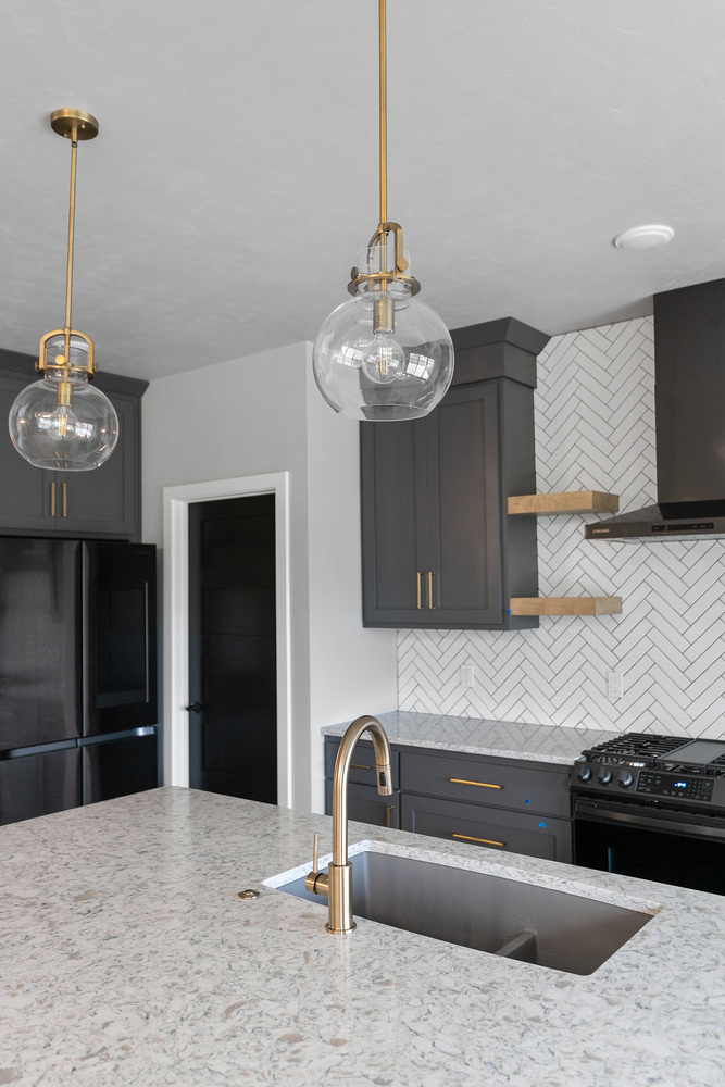 Quartz kitchen island with gold fixtures by Midwest Design Homes in Lawrence WI