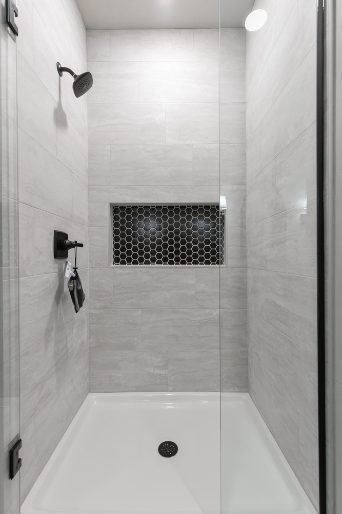 Tiled walk-in shower with black hex accent by Midwest Design Homes in Kaukauna Wisconsin