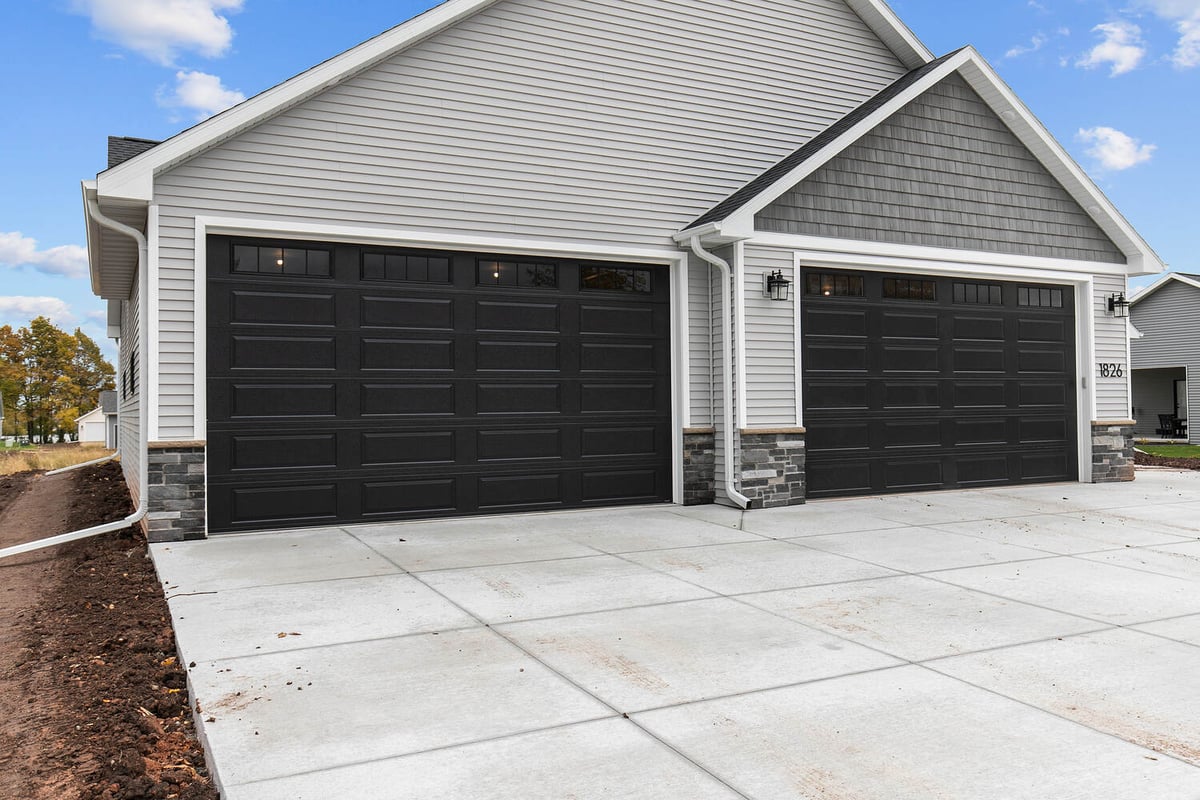 Triple garage with black doors and gray siding by Midwest Design Homes in Appleton WI