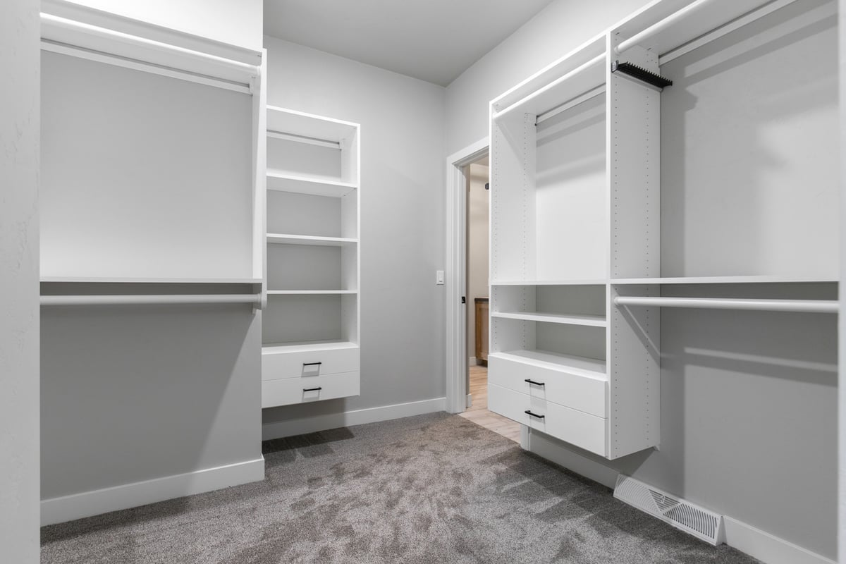 White walk-in closet in Wisconsin custom home by Midwest Design Homes with built-in storage