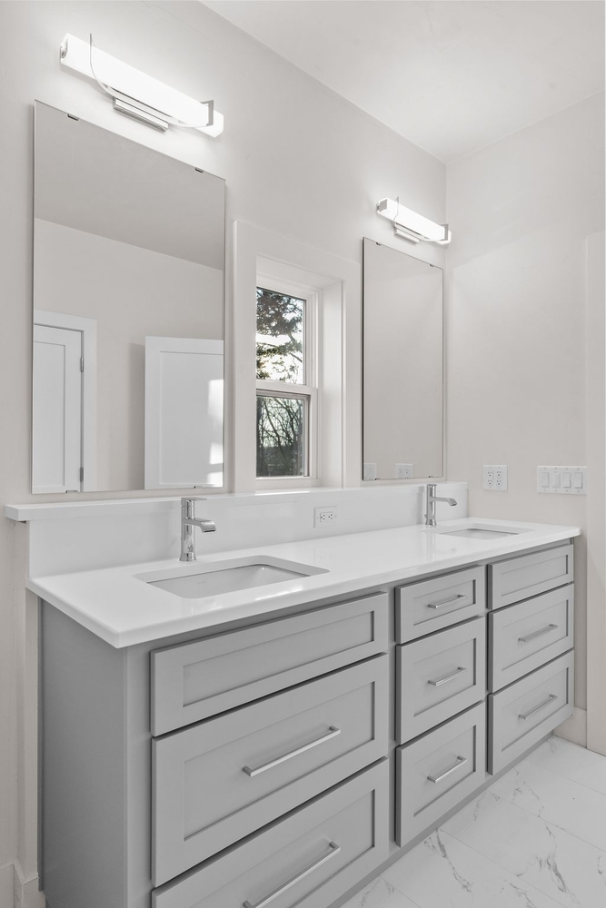 Dual-sink vanity with mirrors in custom home bathroom by Midwest Design Homes, Kaukauna WI