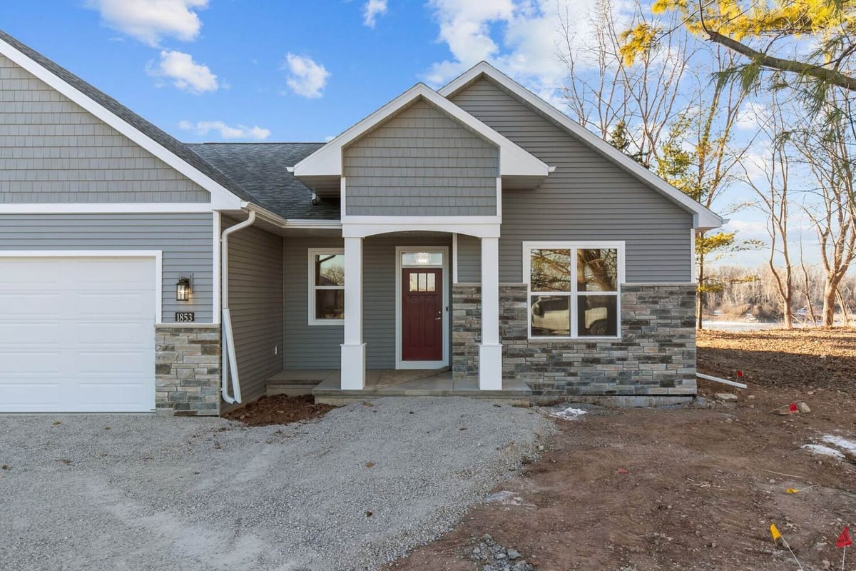 Front entry of gray siding home with red door by Midwest Design Homes in Kaukauna, Wisconsin
