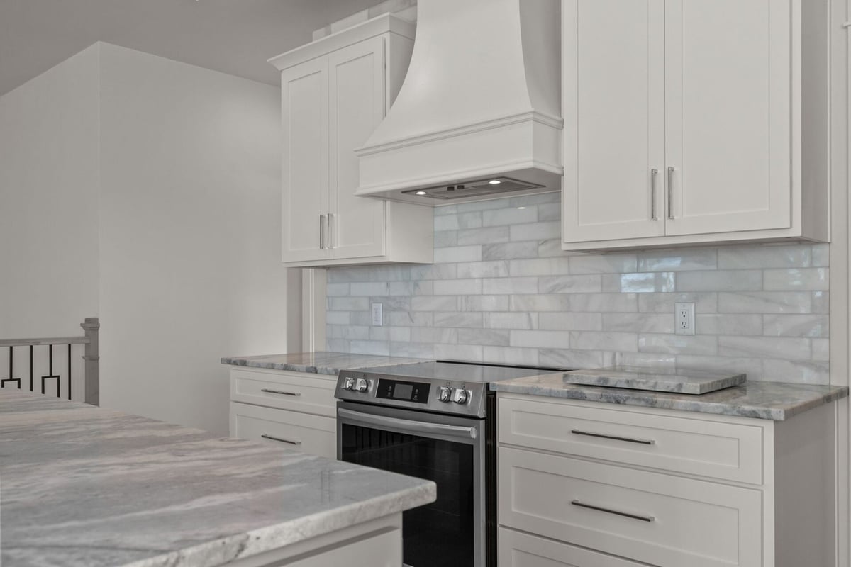 Marble kitchen island and range in custom Kaukauna home by Midwest Design Homes