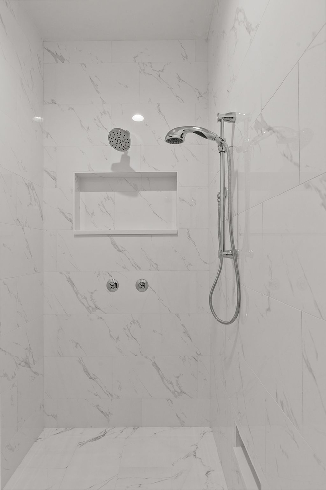 Marble tile walk-in shower with dual heads by Midwest Design Homes in Kaukauna, Wisconsin