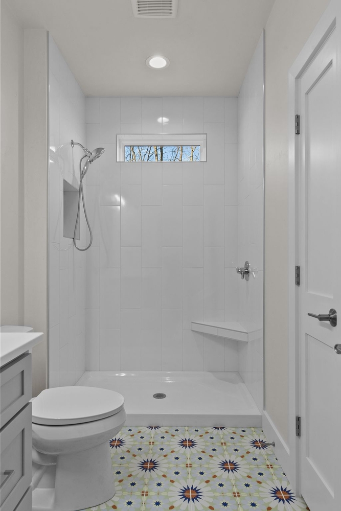 Modern walk-in shower with bench and accent window by Midwest Design Homes, Kaukauna WI