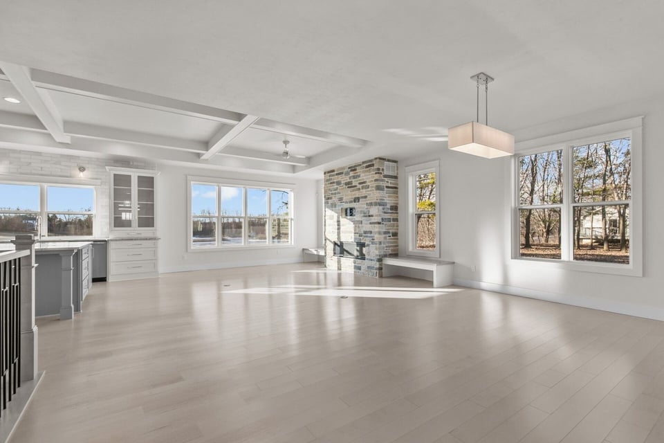 Open concept living room and kitchen with stone fireplace by Midwest Design Homes, WI