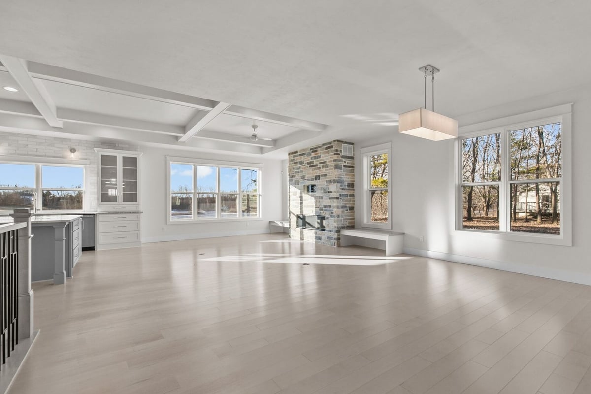 Open concept living room and kitchen with stone fireplace by Midwest Design Homes, WI