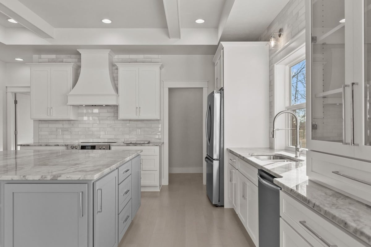 Open kitchen layout with marble island by Midwest Design Homes in Kaukauna, Wisconsin