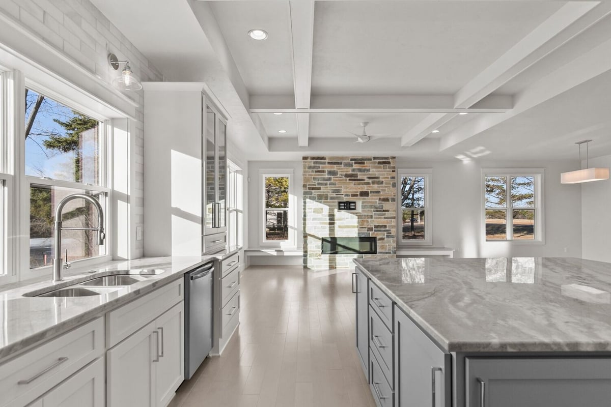 Open kitchen with large island and fireplace view by Midwest Design Homes in Kaukauna, WI