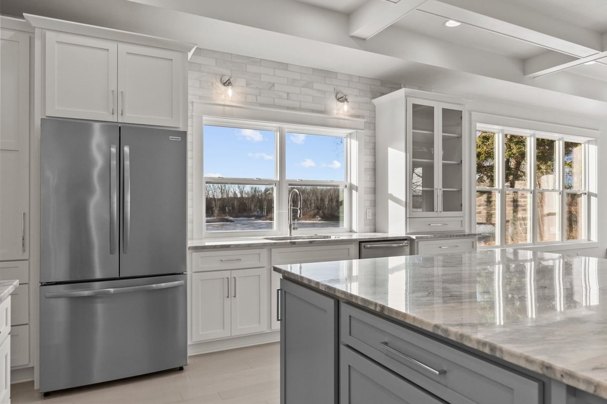 Stainless fridge and windowed sink in kitchen by Midwest Design Homes in Kaukauna, WI