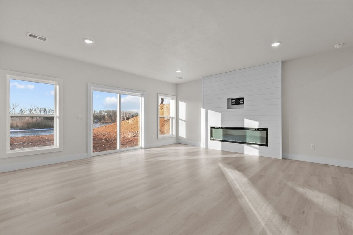 Sunlit room with shiplap fireplace and slider door by Midwest Design Homes in Wisconsin