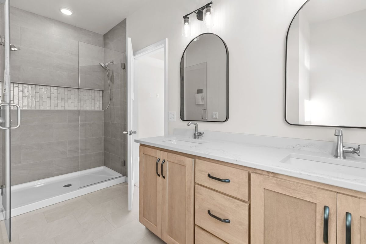 Bathroom with dual sinks and walk-in shower by Midwest Design Homes in Ledgeview, WI