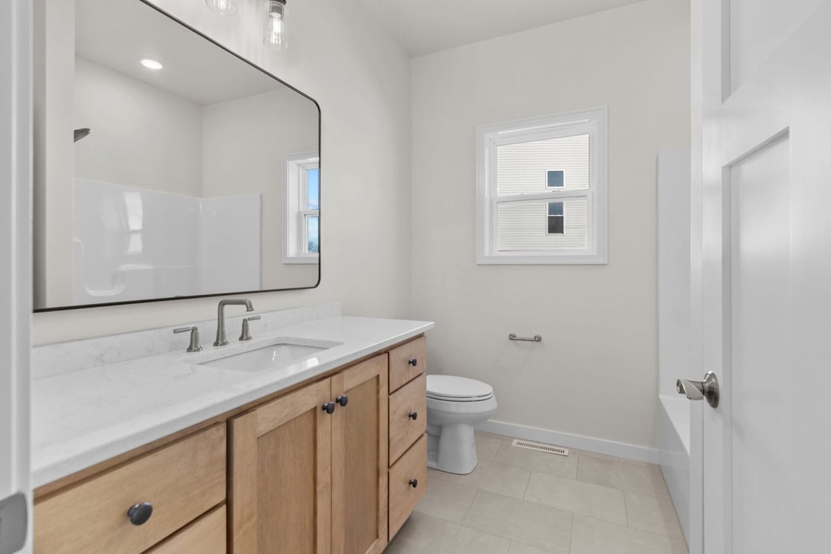 Bathroom with large mirror and natural light by Midwest Design Homes in Greenville, WI