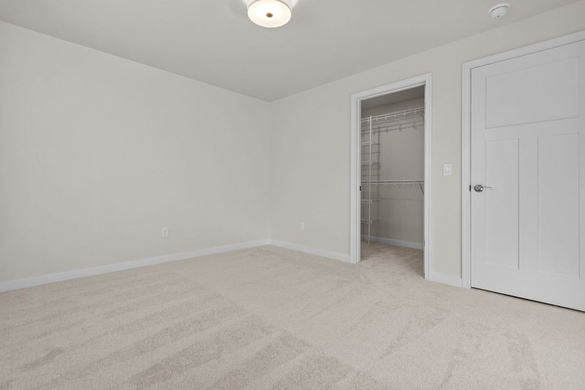 Bedroom with walk-in closet in custom home by Midwest Design Homes in Harrison, WI