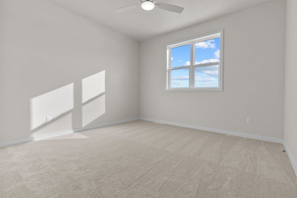 Bright bedroom with large window by Midwest Design Homes in Kaukauna, Wisconsin