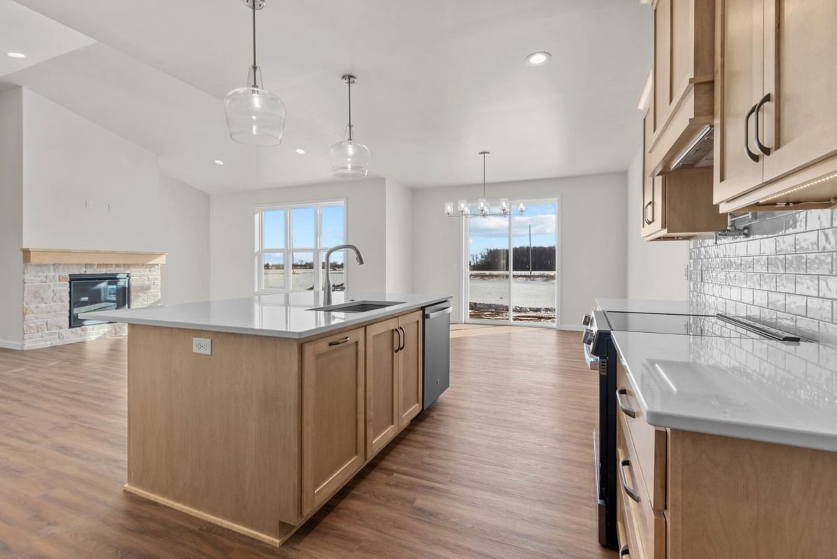 Bright kitchen with island and pendant lights by Midwest Design Homes in Fox Cities, WI