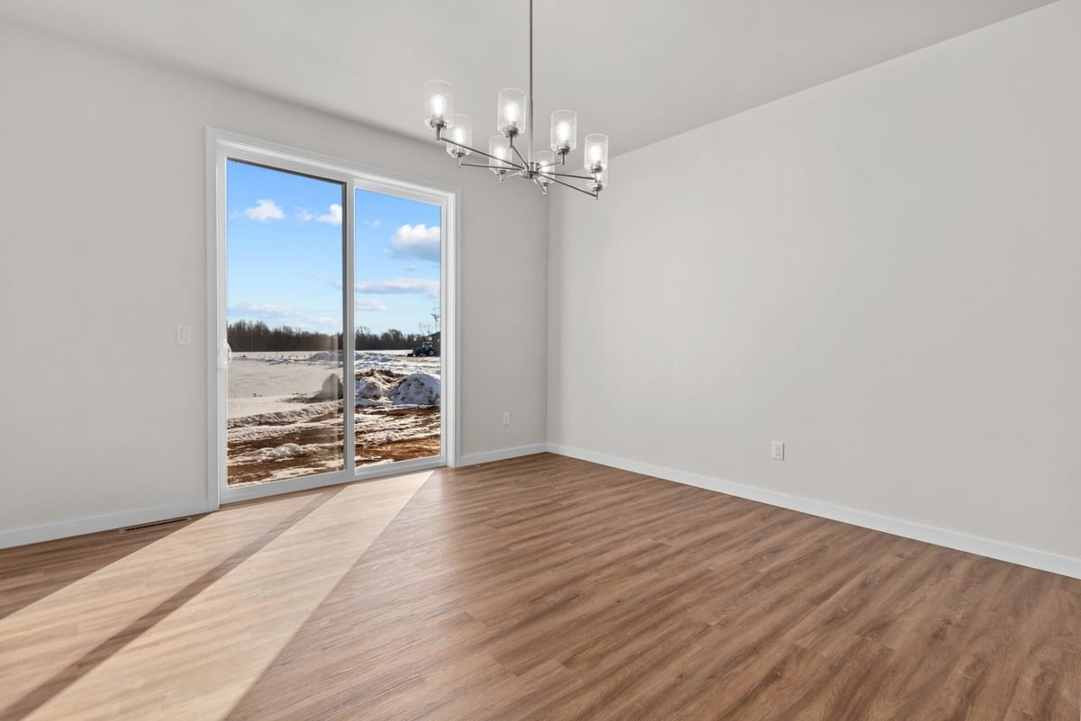 Dining area with wood floors and modern chandelier by Midwest Design Homes in Appleton, WI