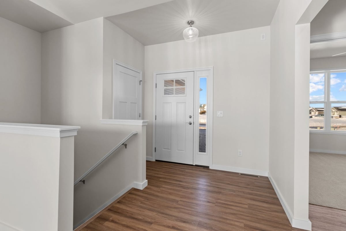 Entryway with wood floors and white door in custom home by Midwest Design Homes, WI
