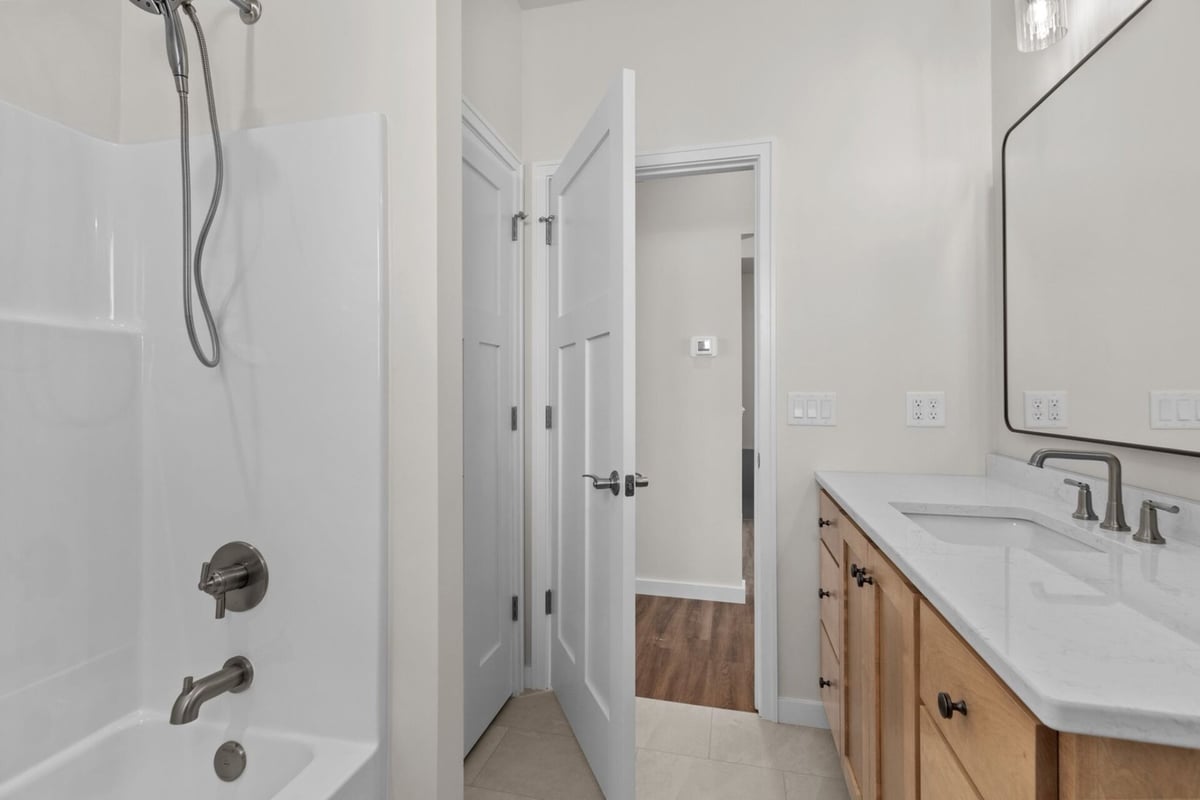 Full bathroom with tub and custom cabinetry by Midwest Design Homes in Neenah, WI