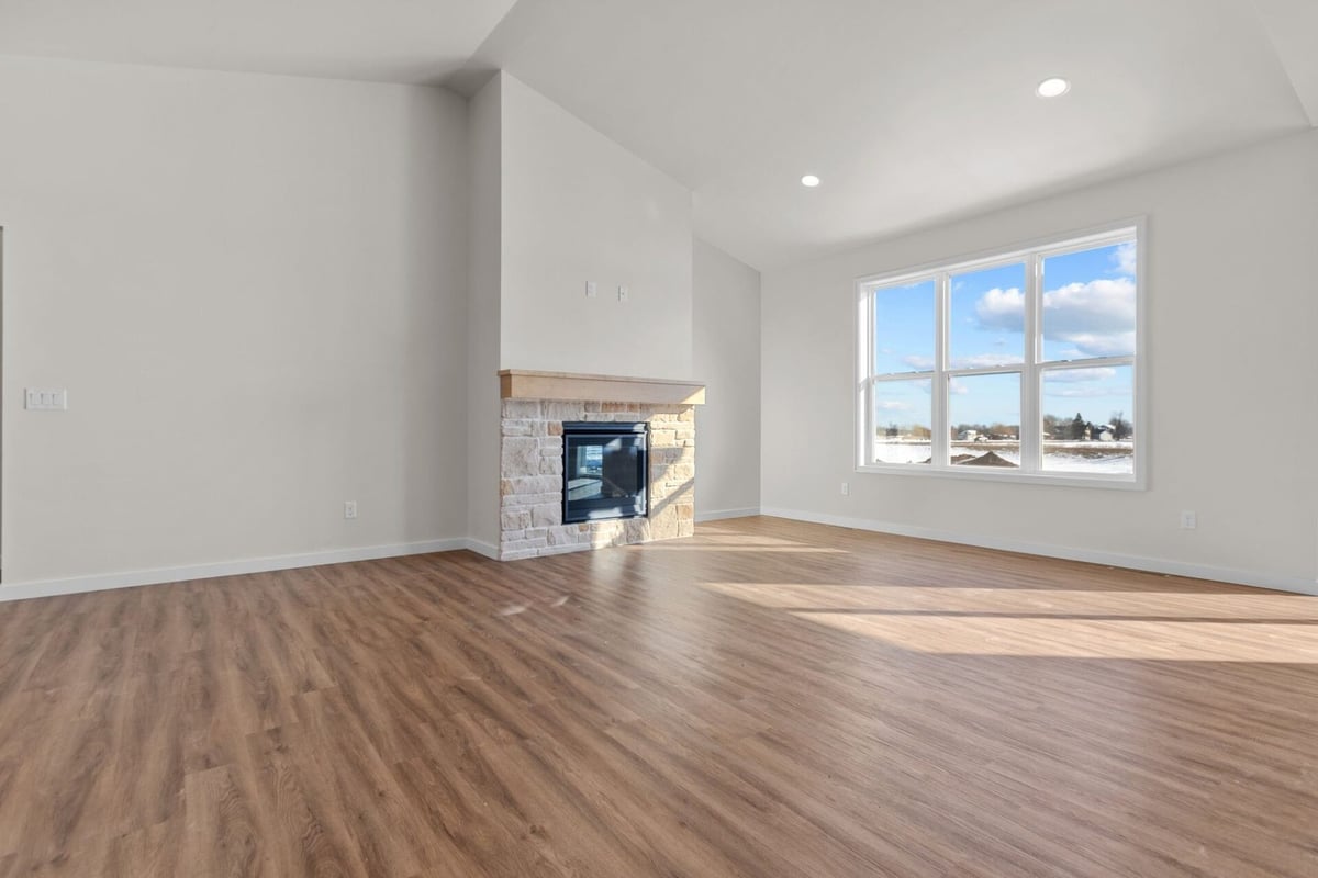 Great room with stone fireplace and large windows by Midwest Design Homes in Fox Cities, WI