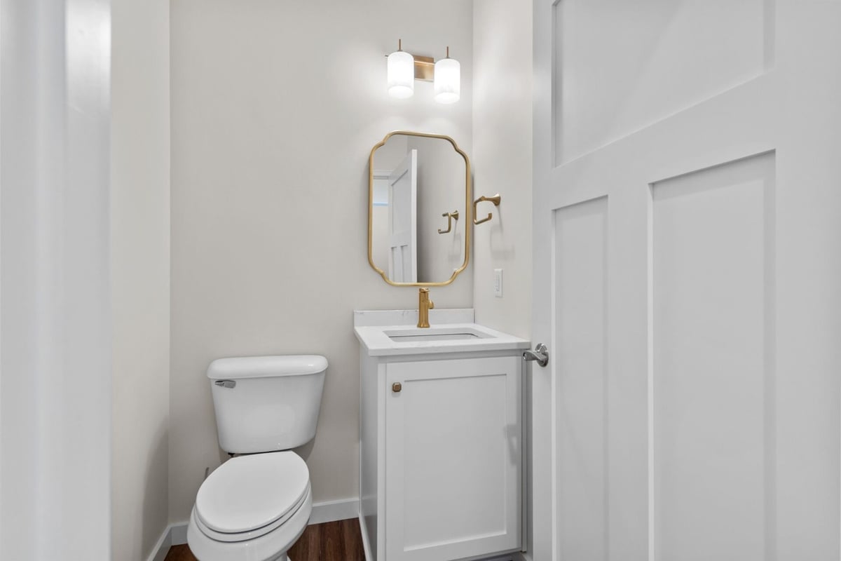 Half bathroom with gold mirror and faucet in a Midwest Design Homes custom home, WI