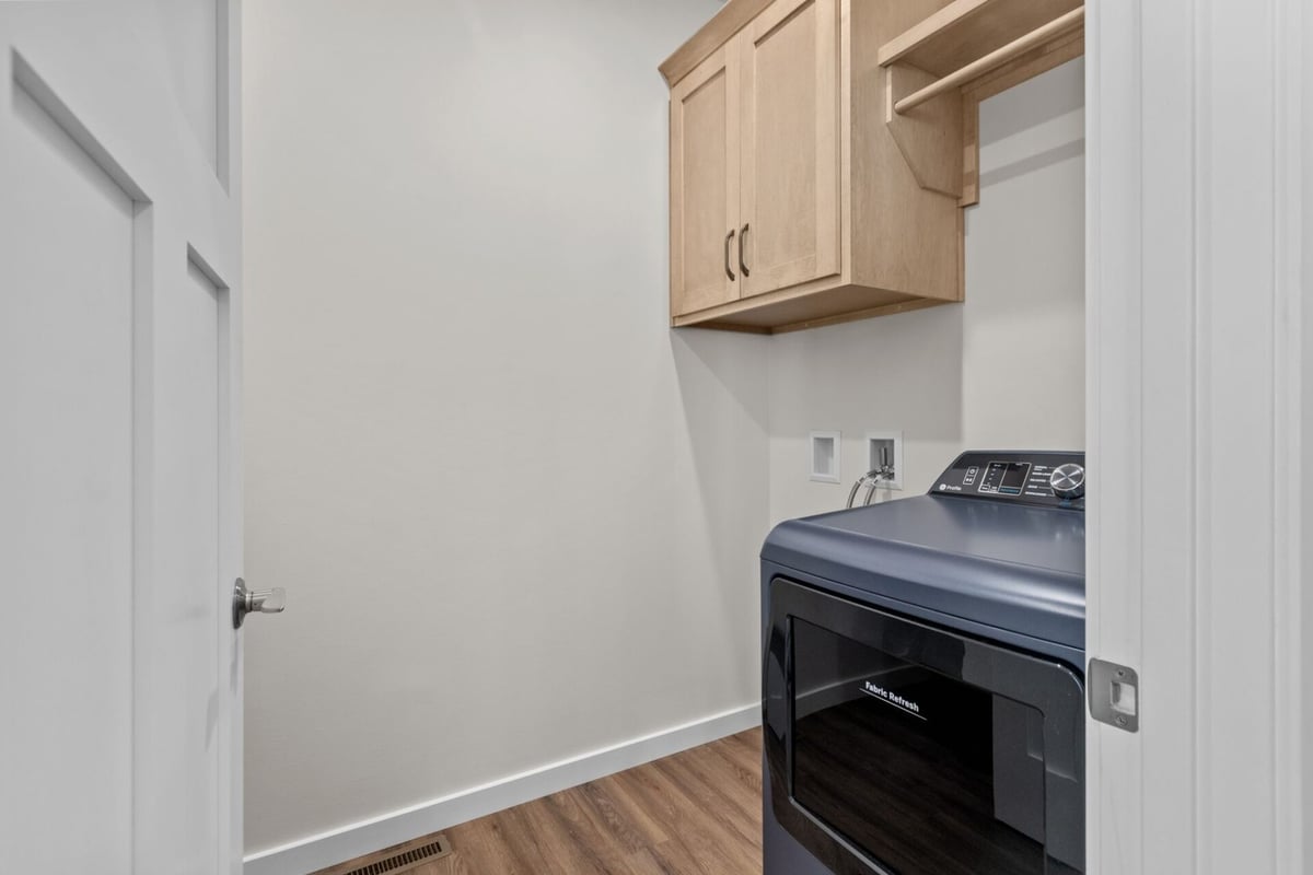 Laundry room with wood cabinetry in a Midwest Design Homes custom home in Kaukauna, WI