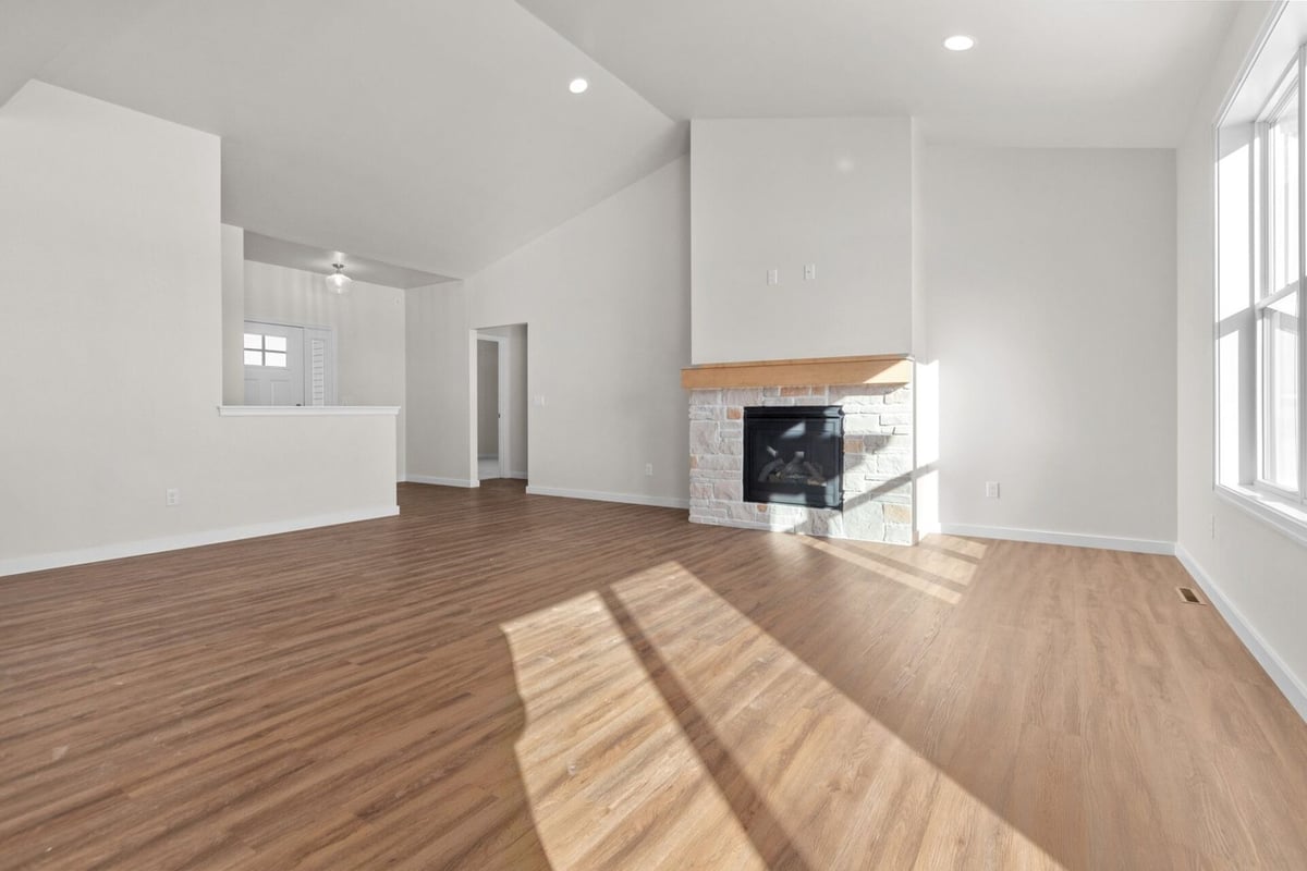 Open living room with fireplace and vaulted ceiling by Midwest Design Homes, Kaukauna, WI