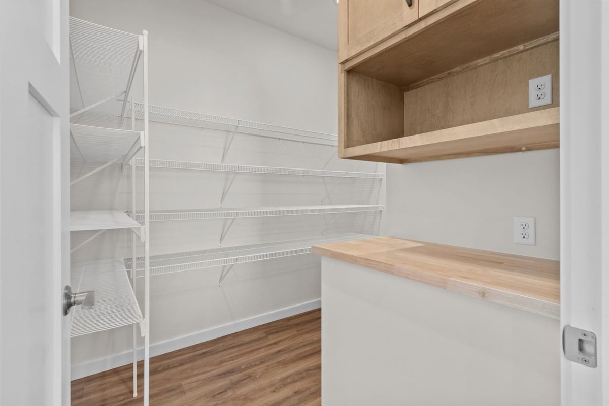 Pantry with white wire shelving and wood top by Midwest Design Homes in Bellevue, Wisconsin