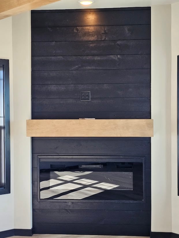 Black shiplap fireplace with wood mantel by Midwest Design Homes, Kaukauna, Wisconsin