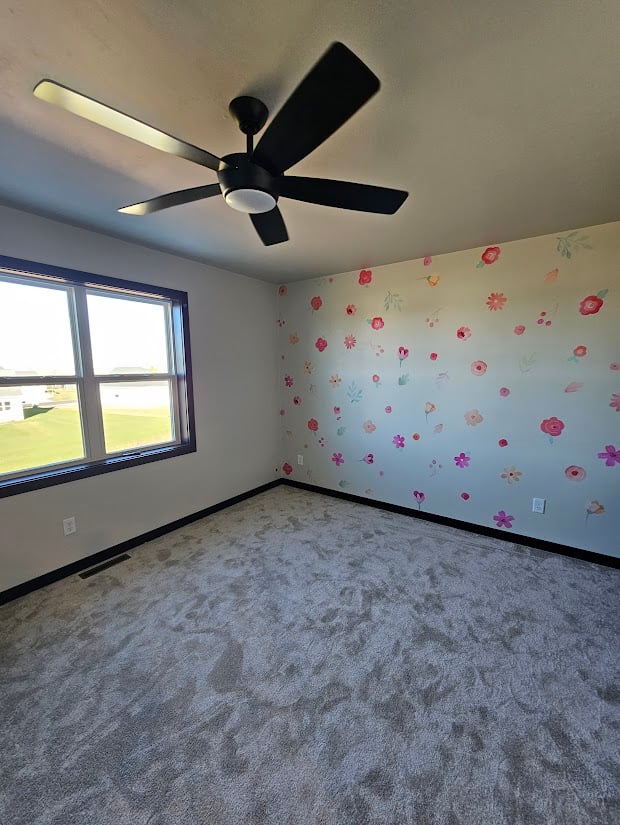 Custom bedroom with floral accent wall and ceiling fan by Midwest Design Homes, WI