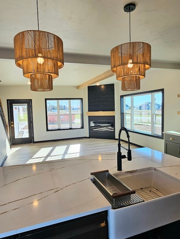 Custom home kitchen with pendant lights and fireplace view by Midwest Design Homes