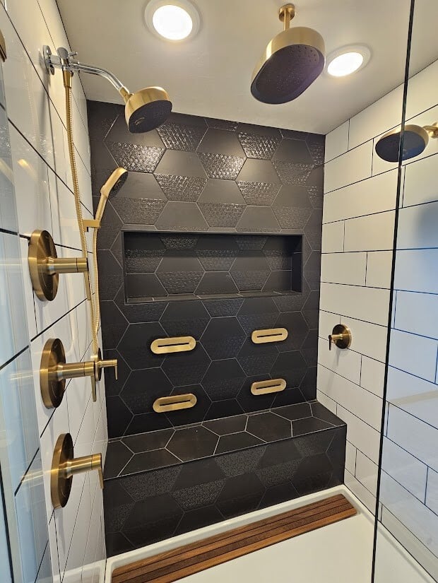 Custom shower with black hex tile and gold fixtures by Midwest Design Homes, Wisconsin