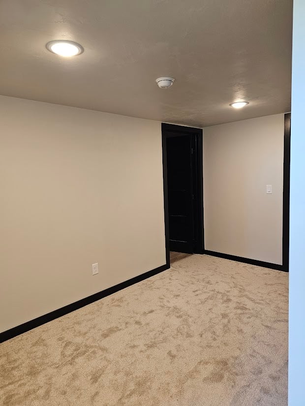 Neutral hallway with recessed lighting in custom home by Midwest Design Homes, Kaukauna