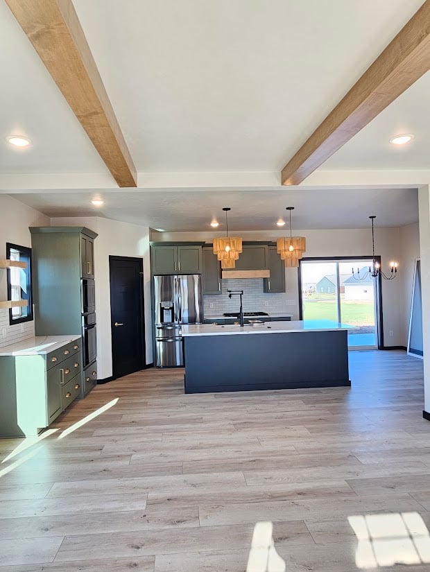 Open kitchen with ceiling beams and island by Midwest Design Homes, Kaukauna, Wisconsin