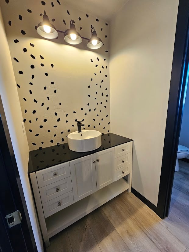 Unique powder room with spotted feature wall by Midwest Design Homes, Kaukauna, WI