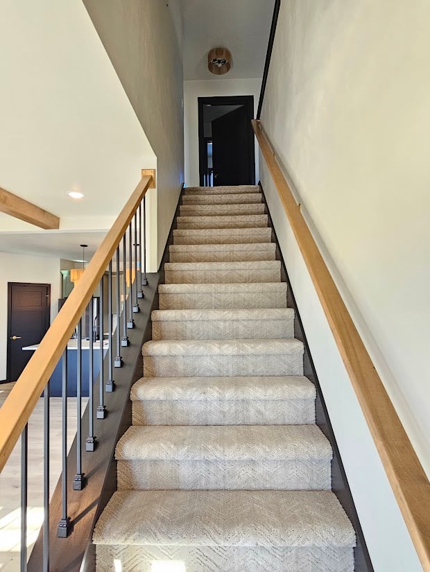 Upper staircase with black railings in custom home by Midwest Design Homes, Wisconsin